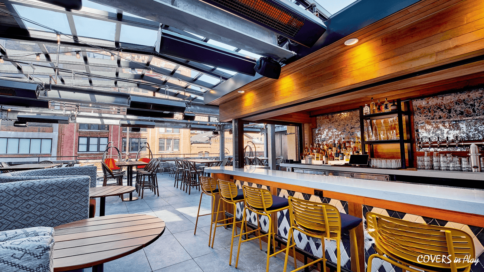 Interior of rooftop restaurant patio enclosure at Puttery in New York City, showing the open air dining area in the city.