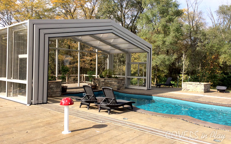 Exterior view of open pool dome cover in Des Moines, IA, with lush greenery.