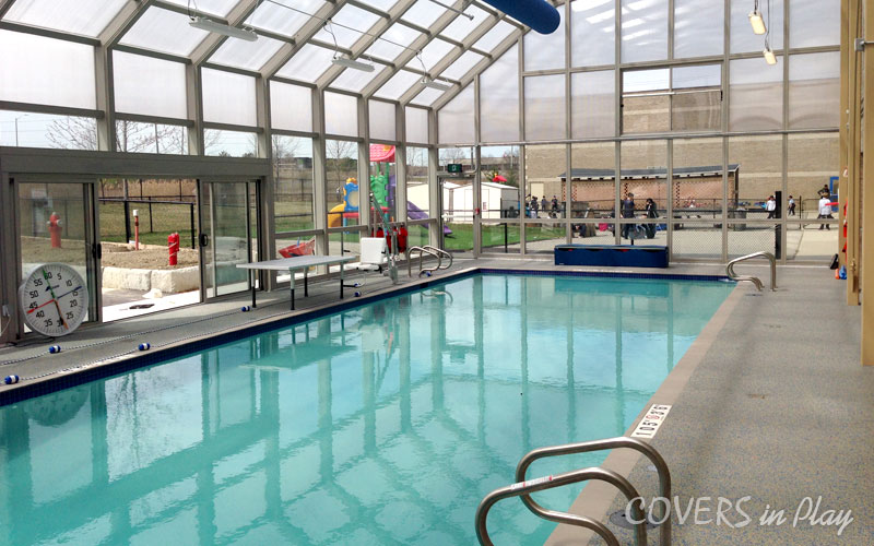 Interior view of commercial swimming pool dome in Mississauga, ON,
            featuring open sliding doors and windows.