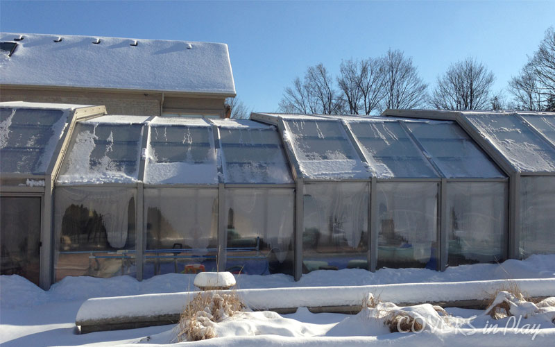 Side view of pool dome cover for winter in Vaughn, ON, with snow
            surrounding the structure.
