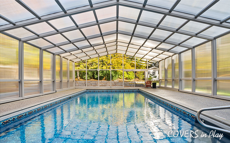 Interior view of closed pool dome cover in Whitby, ON, with beautiful green
            trees in the backyard.